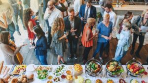 Overhead view of professionals networking and enjoying buffet at stylish corporate reception event.