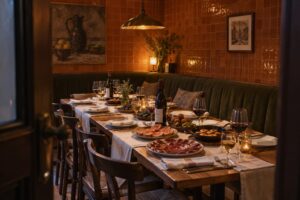 Long table in an enclosed private dining room at a Spanish restaurant, laid with shared tapas, Rioja and sherry before guests arrive